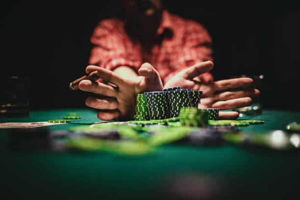 Tumpukan chip poker warna-warni di meja hijau